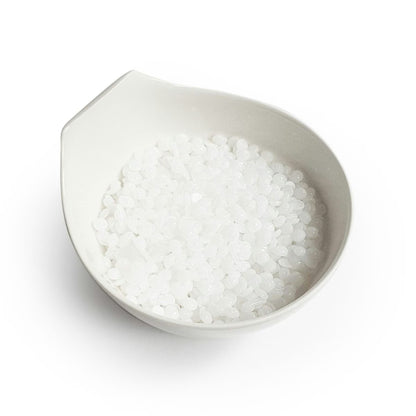 White bowl filled with white pearls on a white background
