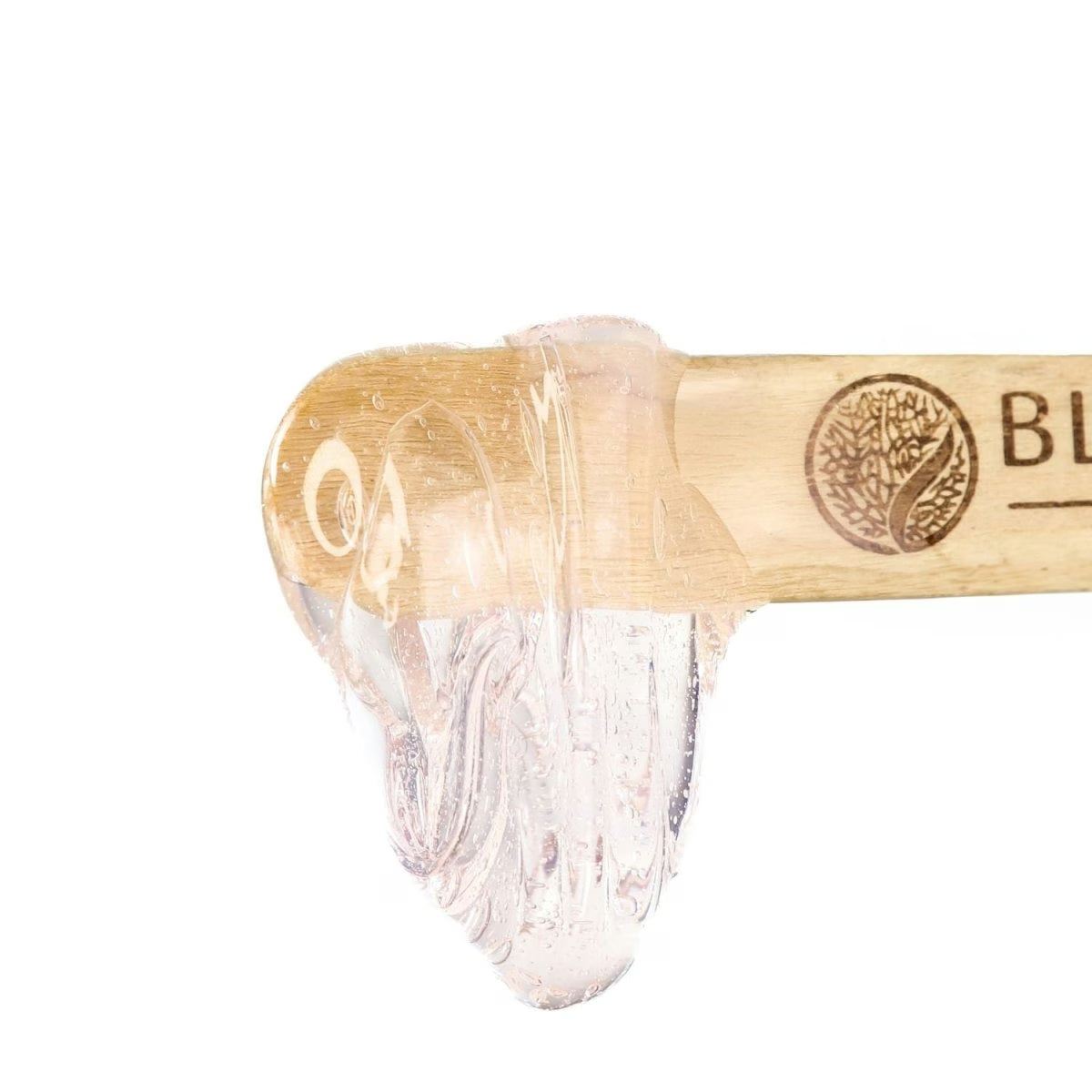 A wooden spatula with a clear, Mae Mae Hard Wax from Black Coral Wax